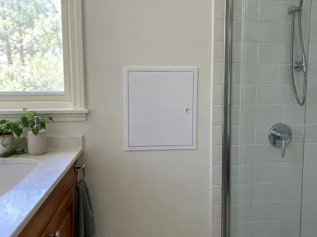 White access panel on a bathroom wall beside a shower and vanity in Killara